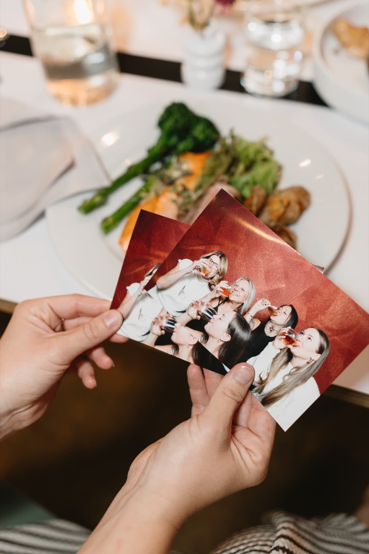 Friends gathered around the table with fresh prints from the MEMORI booth.